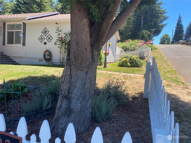 view of side of home featuring a yard, crawl space, and fence