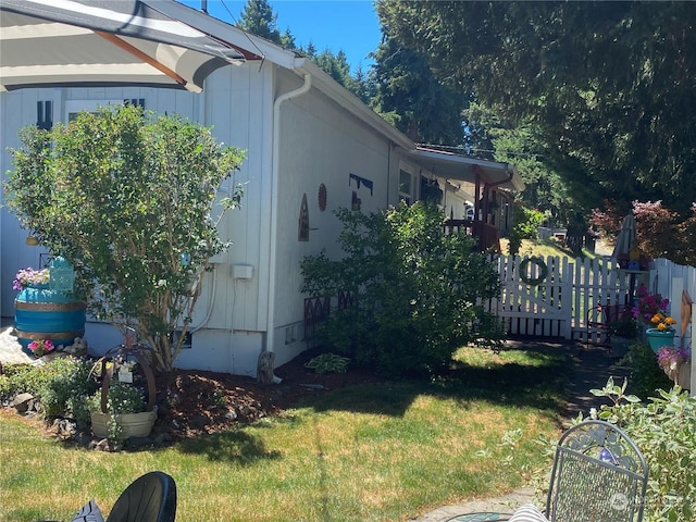 view of home's exterior featuring a yard and fence