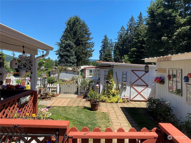 view of yard featuring a storage unit, fence, and an outbuilding