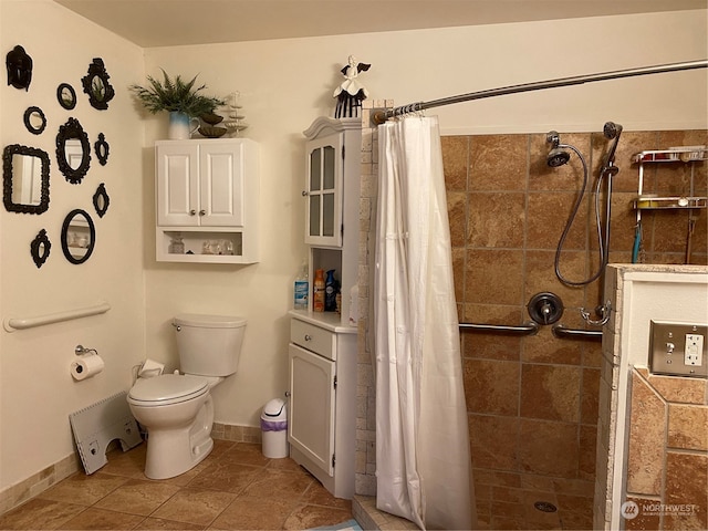 bathroom featuring tile patterned flooring, a shower with curtain, and toilet