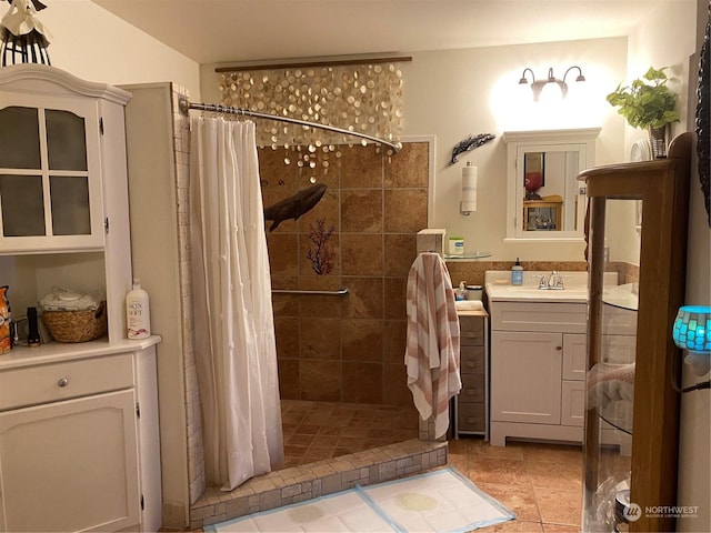 bathroom with vanity, tile patterned flooring, and tiled shower