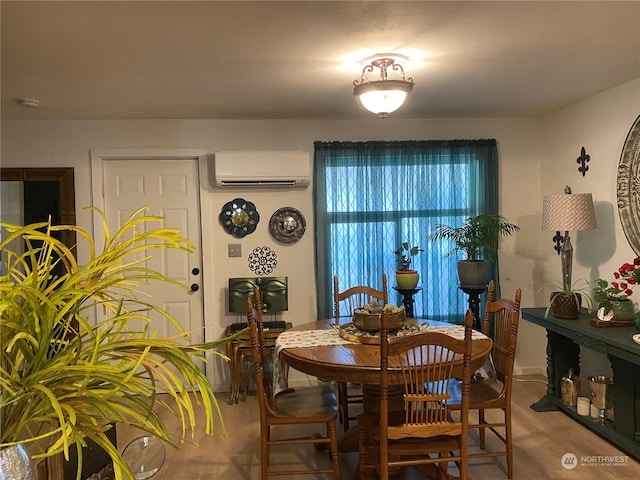 dining area featuring wood finished floors and an AC wall unit