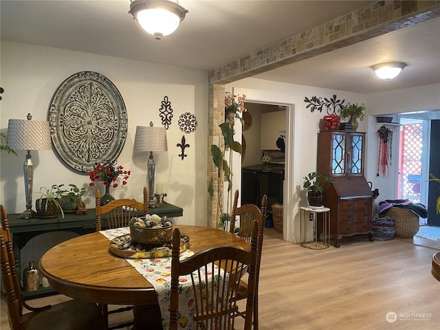 dining room featuring light wood-style floors and separate washer and dryer