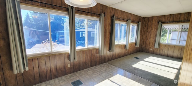 unfurnished room featuring wood walls