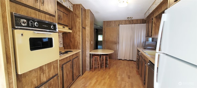 kitchen with stainless steel appliances, a breakfast bar, and light hardwood / wood-style flooring