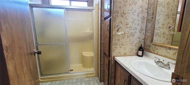 bathroom with vanity and a shower with door