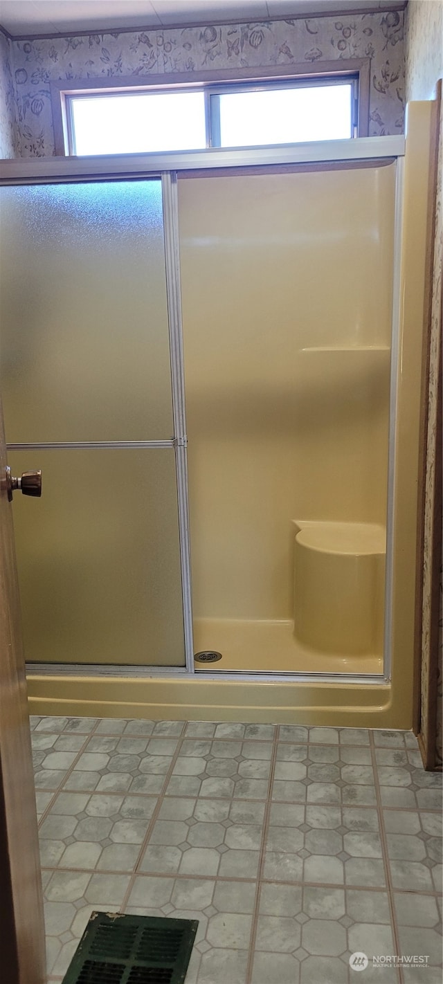 bathroom with a shower with door