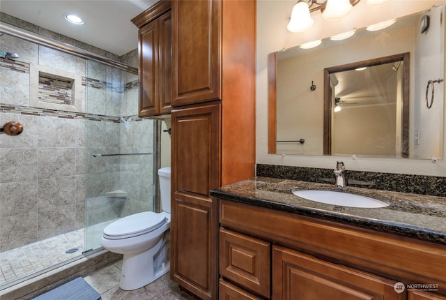 bathroom featuring vanity, toilet, and a shower with door