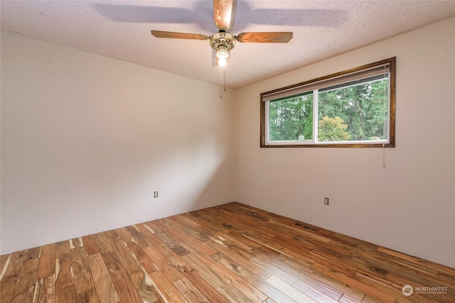 unfurnished room with light wood-type flooring, ceiling fan, and a textured ceiling