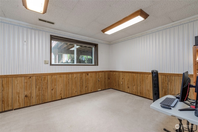 unfurnished room featuring light carpet, a textured ceiling, and wooden walls