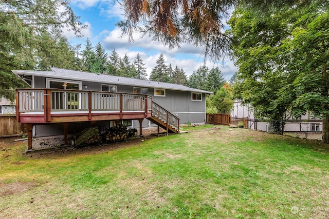 rear view of house with a deck and a yard