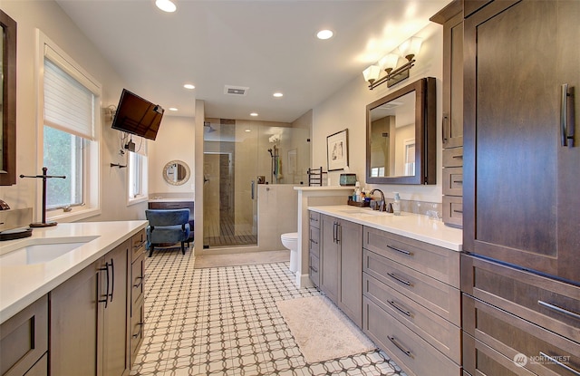 bathroom with vanity, toilet, and an enclosed shower