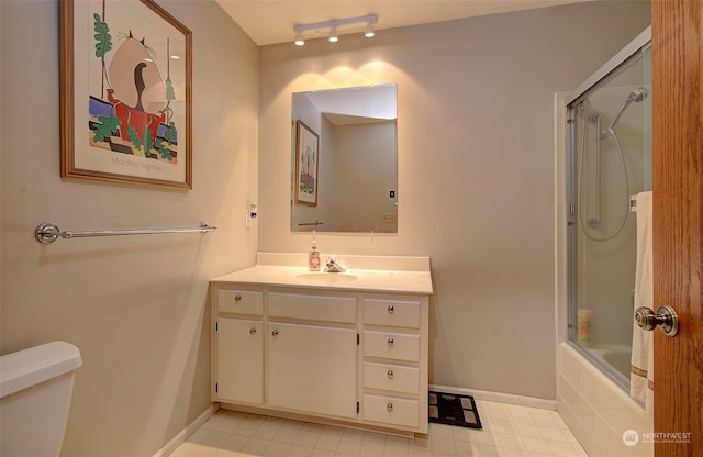 full bathroom featuring combined bath / shower with glass door, vanity, and toilet