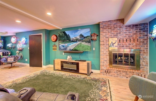 living room with wood-type flooring and a brick fireplace