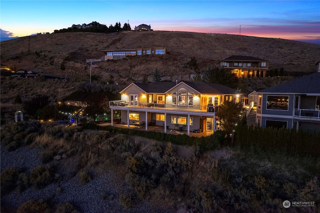 back house at dusk with a balcony