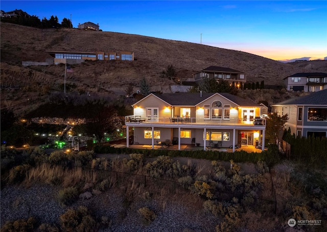 back house at dusk with a balcony