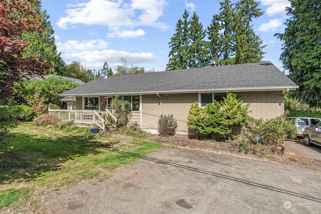 ranch-style home with covered porch and a front yard