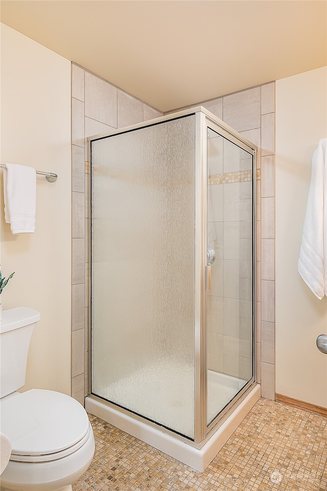 bathroom featuring tile patterned floors, toilet, and walk in shower