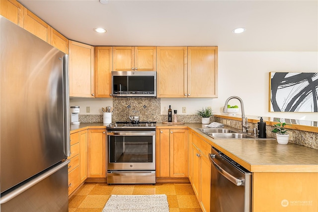 kitchen featuring stainless steel appliances, light brown cabinetry, and sink