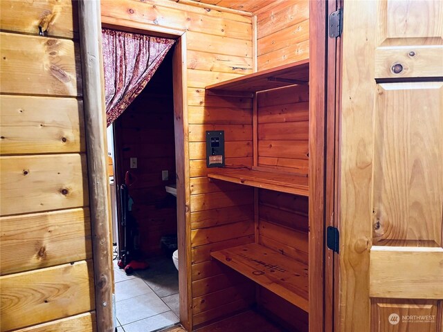 view of sauna / steam room featuring wooden walls and tile patterned floors