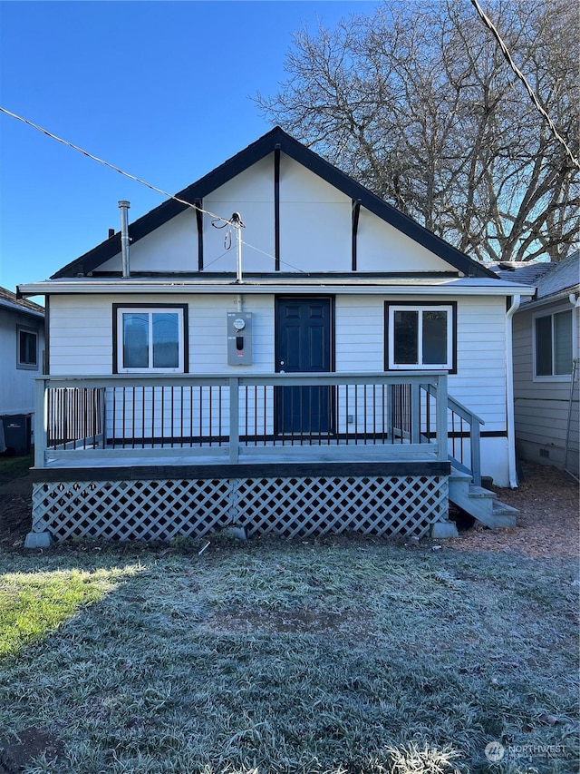 rear view of house with a deck and a yard