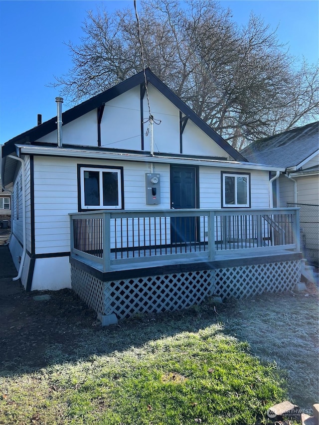 back of house featuring a wooden deck and a yard