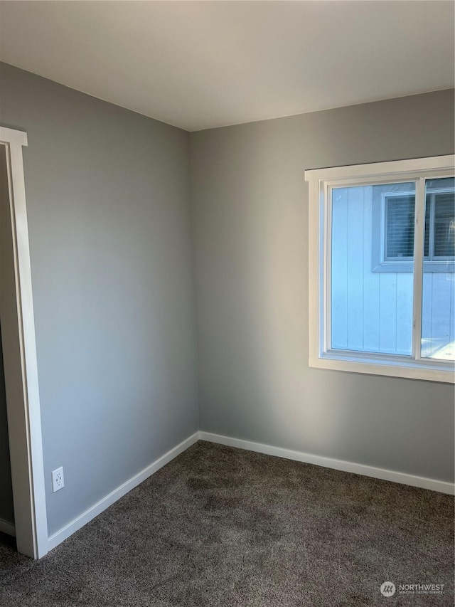 unfurnished room with dark carpet