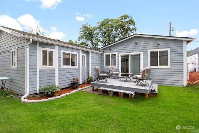 rear view of house featuring a yard and a deck