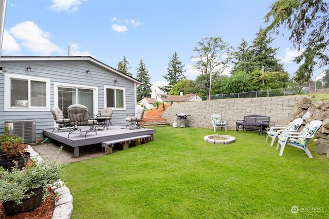 view of yard with an outdoor fire pit, central AC, and a deck