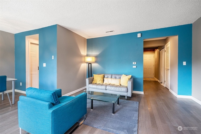 living room featuring a textured ceiling and wood-type flooring