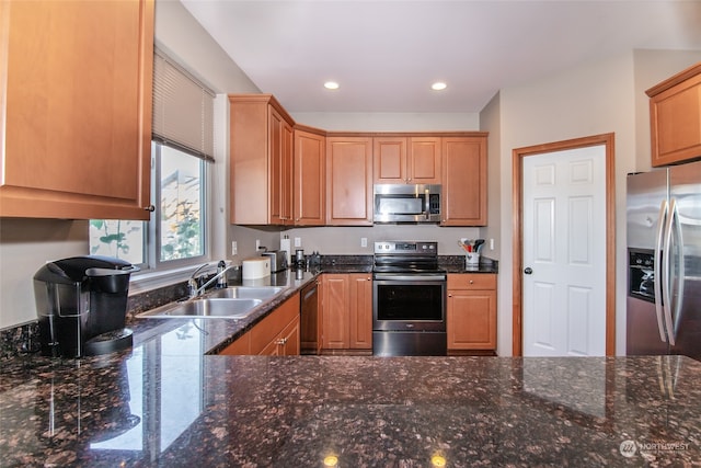 kitchen with dark stone counters, sink, and stainless steel appliances