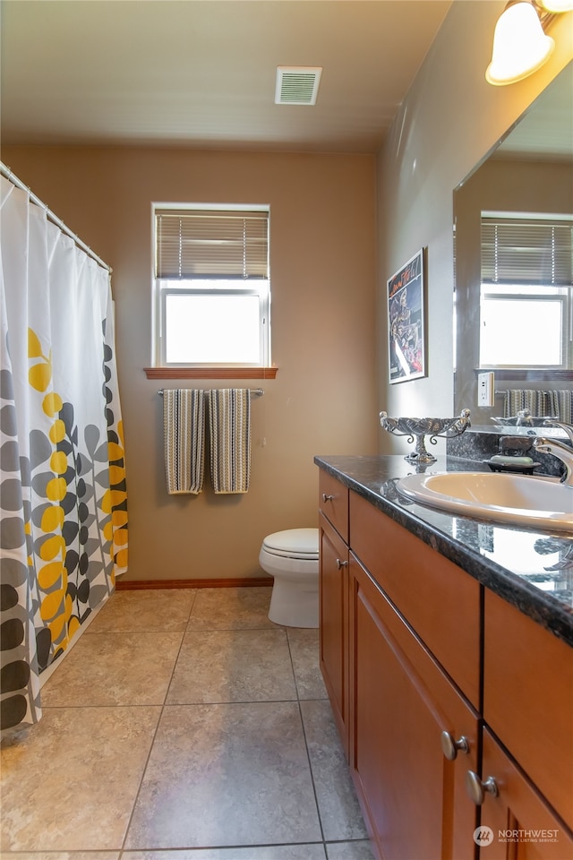 bathroom with vanity, toilet, and tile patterned floors