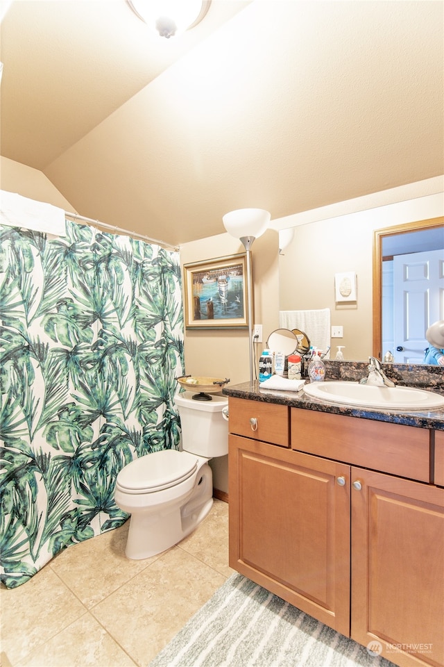 bathroom with vaulted ceiling, vanity, walk in shower, toilet, and tile patterned floors