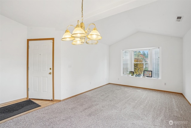 carpeted empty room featuring a chandelier and lofted ceiling