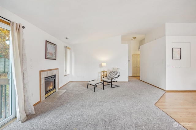 unfurnished room with light carpet and a tile fireplace