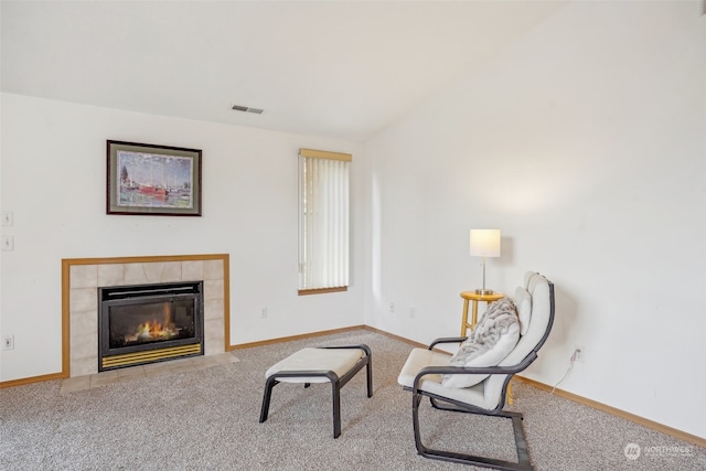 sitting room with a tile fireplace and carpet floors