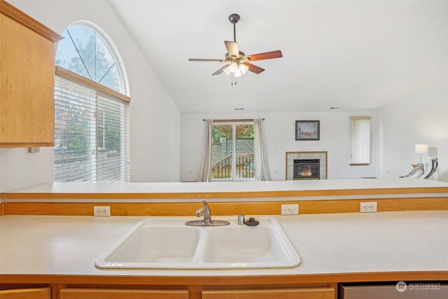 kitchen featuring a fireplace, plenty of natural light, lofted ceiling, and sink