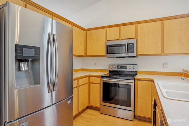 kitchen featuring sink, light hardwood / wood-style floors, light brown cabinets, and appliances with stainless steel finishes