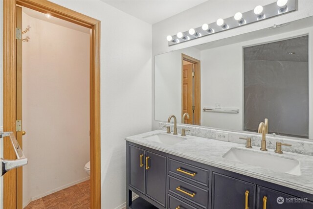 bathroom featuring tile patterned flooring, vanity, and toilet