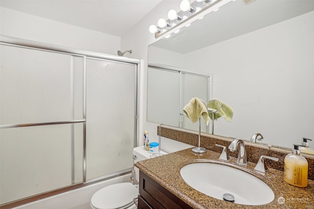 full bathroom featuring vanity, enclosed tub / shower combo, and toilet