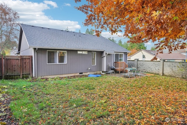 rear view of property featuring a yard