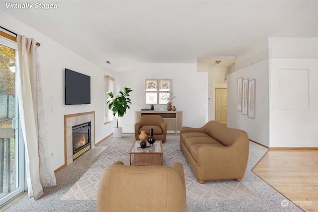 carpeted living room with a tile fireplace