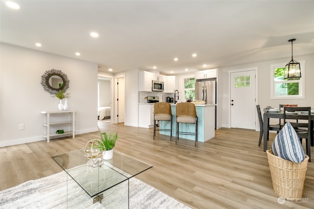 living room with light wood-type flooring and sink