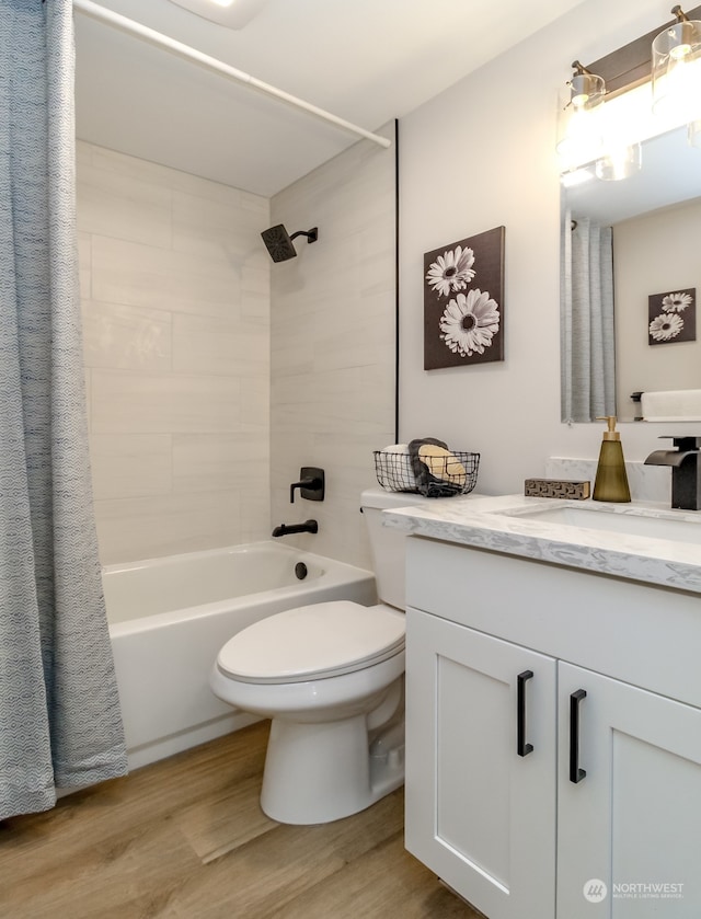 full bathroom with wood-type flooring, shower / tub combo with curtain, vanity, and toilet