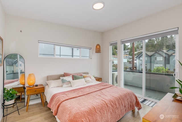 bedroom with access to outside and light wood-type flooring