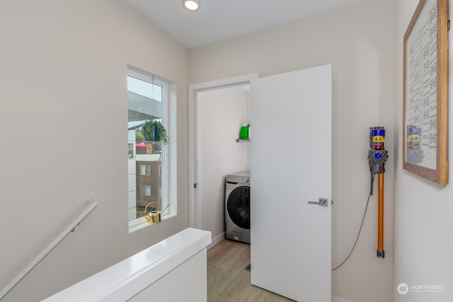 laundry area with light hardwood / wood-style flooring and washer / clothes dryer