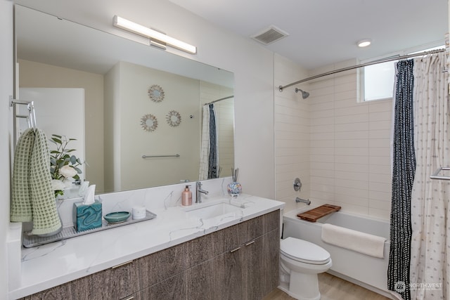 full bathroom with shower / bath combination with curtain, hardwood / wood-style floors, vanity, and toilet