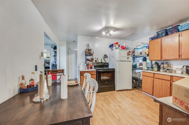 kitchen featuring a textured ceiling, light hardwood / wood-style flooring, electric range, and white refrigerator