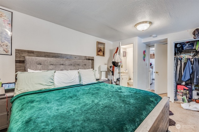 carpeted bedroom with a textured ceiling, a closet, and ensuite bathroom