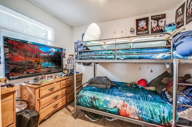 bedroom featuring a textured ceiling and carpet flooring